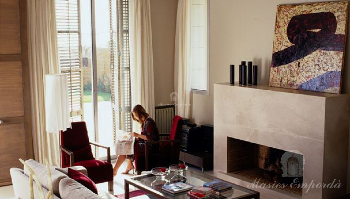 Detalle del salón con chimenea de la casa con vistas a la piscina 