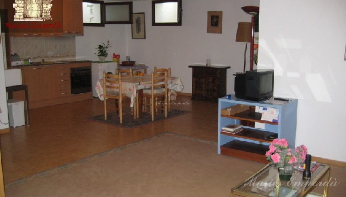 Salón de estar de la planta baja con el comedor y cocina al fondo de la imagen