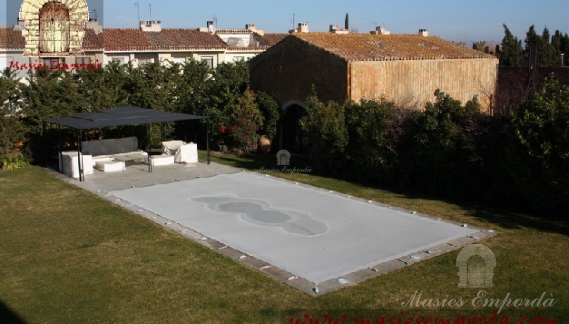 Vista del jardín y la piscina donde se aprecia el pabellón de la piscina 