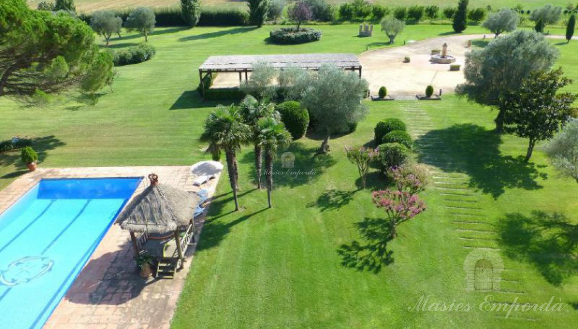 Vista del jardín, piscina y parte de campos del entorno de la finca 