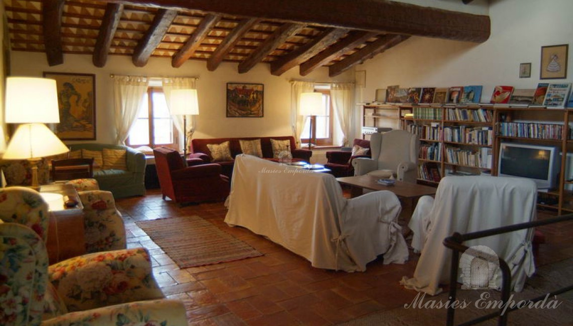 Gran salón muy acogedor con cubierta a dos aguas y vigas de madera vistas  