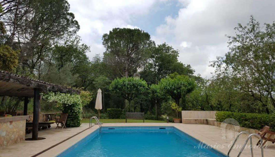 Vista de la piscina y el bar de esta. 