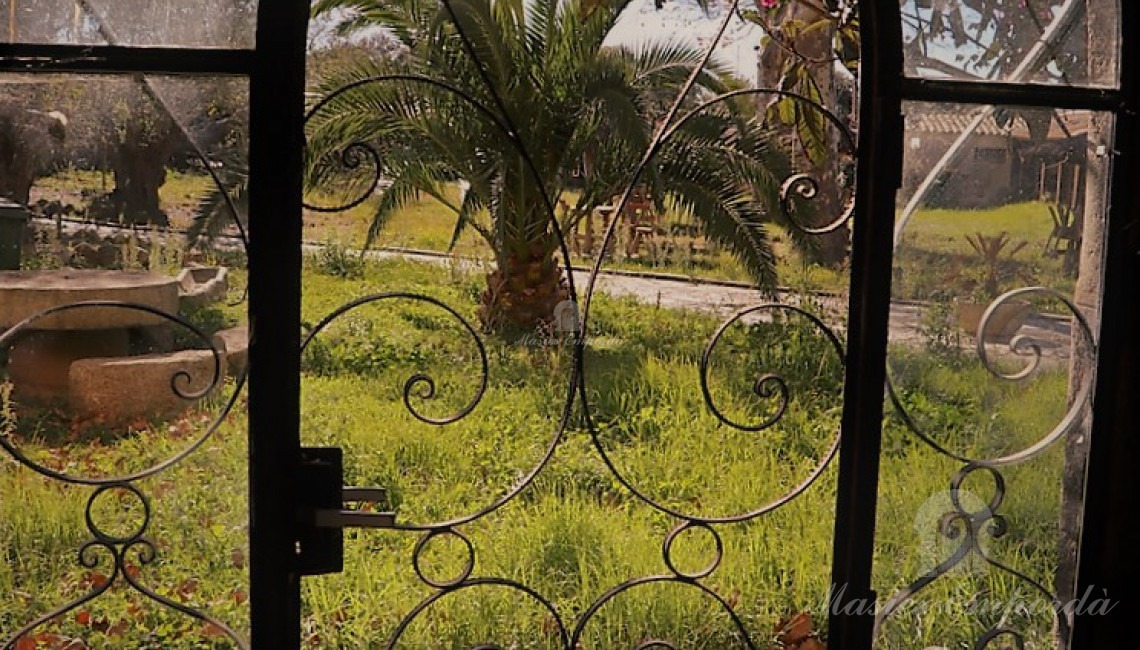 Entrada principal de la masía desde el jardín 