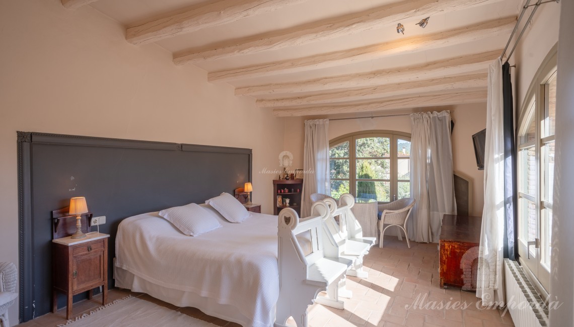 Master bedroom with exit to the terrace and views of the garden and swimming pool