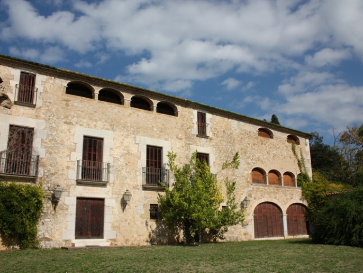 Fachada principal de la masía con jardín 