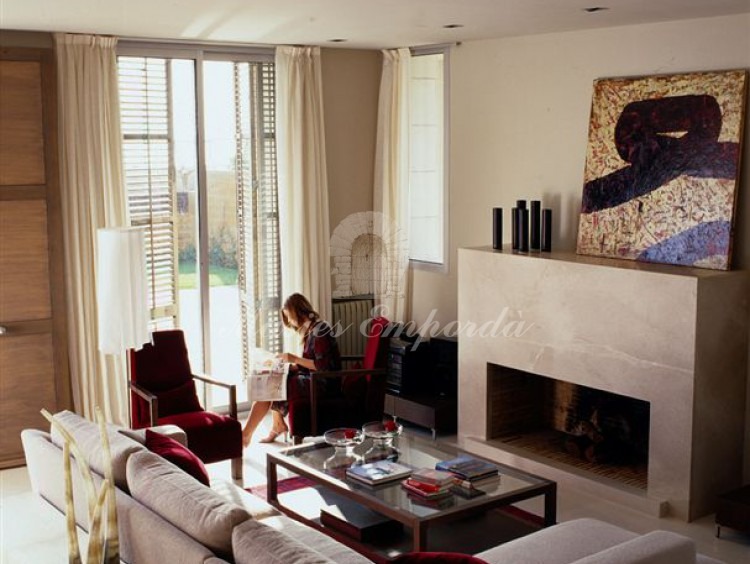 Detalle del salón con chimenea de la casa con vistas a la piscina 